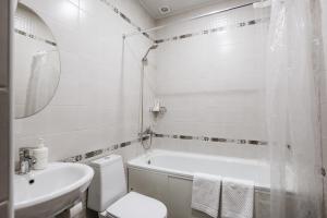 a white bathroom with a toilet and a sink at Nova Hotel in Astrakhan