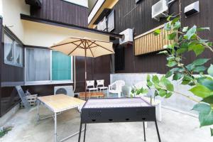 an outdoor patio with a table and an umbrella at Awaji Horiday Inn Kariya in Awaji