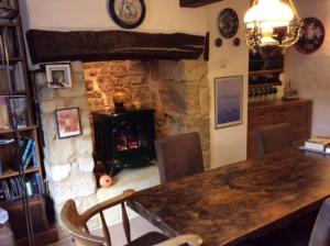 a dining room with a fireplace and a table with chairs at Wheelwrights in Abbotsbury