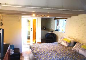 a bedroom with a bed and a chair at Wheelwrights in Abbotsbury