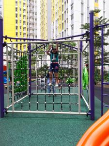 ブカシにあるApartemen Springlake Summarecon Bekasi-By Bu Johanの遊び場で遊んでいる少年