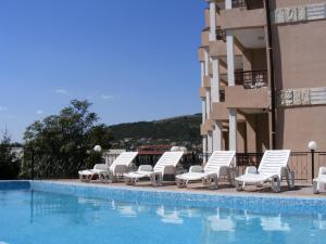 a row of lounge chairs next to a swimming pool at Hotel Naslada in Balchik