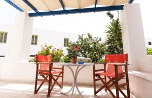 a table and chairs on a patio with flowers at Angeliki's Studios Paros in Parikia