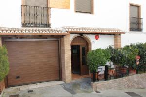 a garage with a brown garage door in front of a building at Apartamentos Haza La Moraleda in Güéjar-Sierra