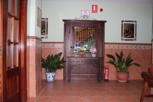 a living room with a large mirror and plants at Apartamentos Haza La Moraleda in Güéjar-Sierra