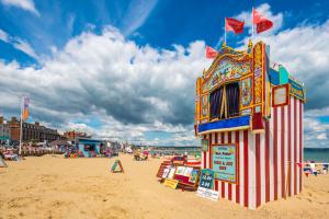 a lifeguard tower on a beach with people on it at Ocean House - Weymouth in Weymouth