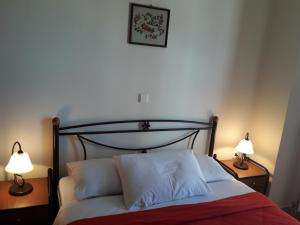 a bedroom with a bed with two lamps on tables at To Pithari in Skiros