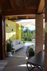 een patio met een bank en een parasol bij Due Lune B&B in Almenno San Salvatore