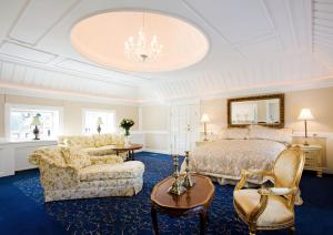 1 dormitorio con cama, sofá y sillas en Skrøbelev Gods Manor House en Rudkøbing