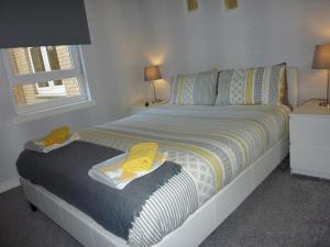 ein Schlafzimmer mit einem Bett mit gelben Handtüchern darauf in der Unterkunft Paisley Central Apartment #2 in Paisley
