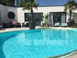 una grande piscina blu in un cortile di La Palmeraie a Vannes