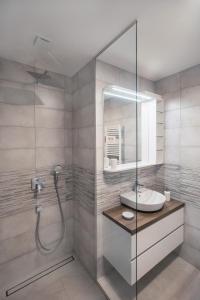 La salle de bains est pourvue d'un lavabo et d'une douche. dans l'établissement APARTMA KATKA Vila Mojca, à Kranjska Gora
