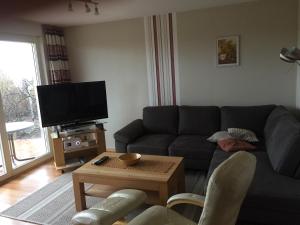 ein Wohnzimmer mit einem Sofa und einem TV in der Unterkunft Am Ringwall 76 in Cuxhaven