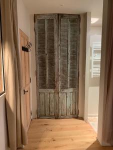 a room with a large wooden door in a room at T2 intra muros clim et cour ombragée in Avignon