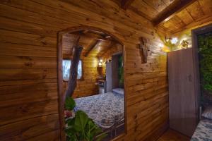 a mirror in a wooden room with a bed at Casa sull'albero Bocchineri in Rogliano