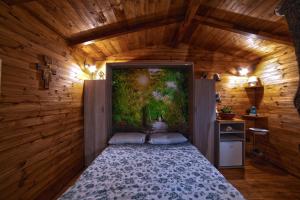 a bedroom with a bed with a painting on the wall at Casa sull'albero Bocchineri in Rogliano