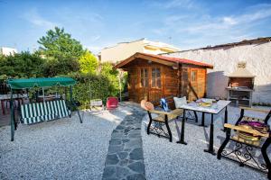 a patio with a table and chairs and a house at Holiday House Ioanna in Nea Peramos