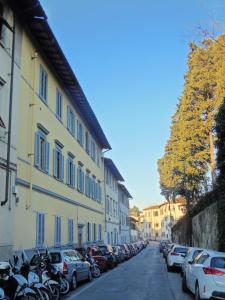 een straat met auto's geparkeerd naast een gebouw bij L'Albero di Garibaldi in Florence