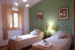 two beds in a room with green walls at Podere Le Lame Farmhouse in Riparbella