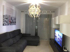 Telewizja i/lub zestaw kina domowego w obiekcie Apartamento Lujo, Primera linea playa, Garaje, Wifi, Piscina climatizada