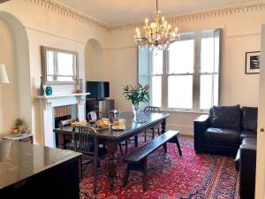 a living room with a dining room table and a couch at Waves End, St Ives, Hot tub and Parking in St Ives