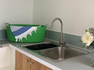 a kitchen counter with a sink and a green bucket at Waves End, St Ives, Hot tub and Parking in St Ives +25 photos