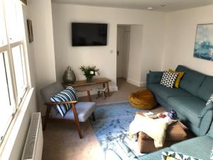 una sala de estar con un sofá y una mesa en Waves End, St Ives, Hot tub and Parking, en St Ives