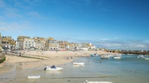 una playa con barcos en el agua y edificios en Waves End, St Ives, Hot tub and Parking, en St Ives