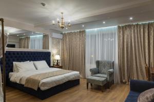 una camera da letto con un letto king size e una sedia di Omart Hotel - Gallery a Tbilisi City