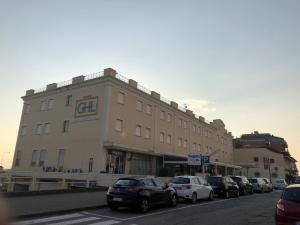 un gran edificio con coches estacionados frente a él en Grand Hotel Lamezia, en Lamezia Terme