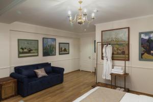 un soggiorno con divano blu e dipinti di Omart Hotel - Gallery a Tbilisi City