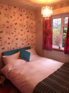 sypialnia z łóżkiem z kwiatami na ścianie w obiekcie 11 Callow Crescent w mieście Minsterley