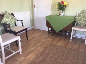 Pokój ze stołem i krzesłami oraz wazonem z kwiatami w obiekcie 11 Callow Crescent w mieście Minsterley