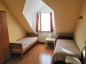 a small room with two beds and a window at Willa Elżbieta in Krakow