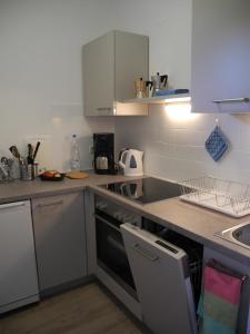 kuchnia z białymi szafkami i kuchenką w obiekcie Apartment Stubnerkogelblick w mieście Bad Hofgastein +5 zdjęć