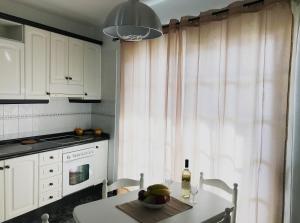 a kitchen with white cabinets and a table with a bottle of wine at Alojamiento San Antonio in Valle Gran Rey