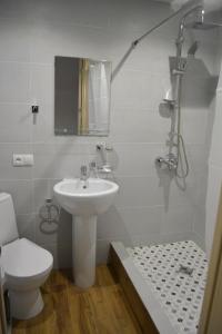a white bathroom with a sink and a toilet at Modern Apartment in Villa Monte in Bakuriani