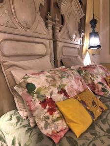 1 cama con cabecera blanca y manta floral en L'Ape Regina, en Ferrara