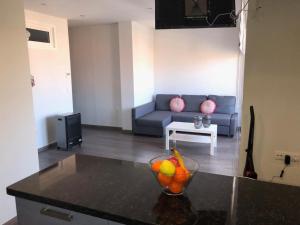 una sala de estar con sofá y un bol de fruta en una mesa en Avenida de las Piletas, en Sanlúcar de Barrameda