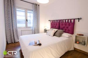 a bedroom with a large white bed with a purple headboard at Spacious & Modern Apartment in Santiago de Compostela
