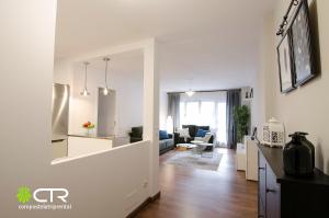 a white living room with a kitchen and a living room at Spacious & Modern Apartment in Santiago de Compostela