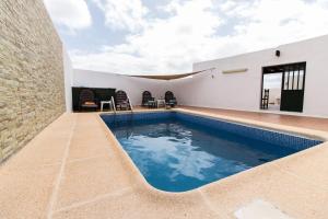 a swimming pool in the backyard of a house at Casa Nora in Güime