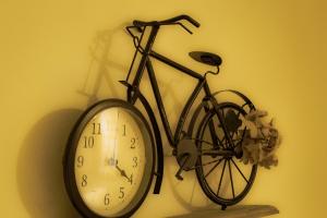 Una bicicleta colgada en una pared junto a un reloj en Little garden house, en Rijeka