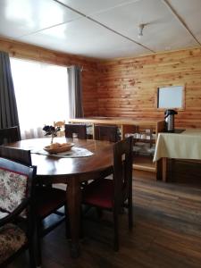 a wooden dining room with a table and chairs at Puesto Cánogas Hostal in Villa O'Higgins