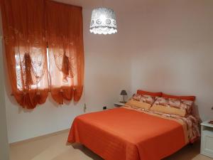 Un dormitorio con una cama con una manta naranja. en M&A Relax, en Martina Franca
