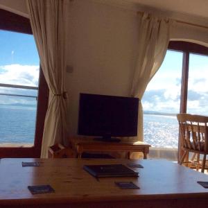 a living room with a television and a table with a tableablish at 3 Marina Quay in Lossiemouth