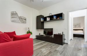 uma sala de estar com um sofá vermelho e uma televisão em Porta Latina Suite - Private Apartment Rome's Center em Roma