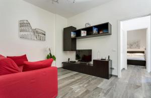 ローマにあるPorta Latina Suite - Private Apartment Rome's Centerのリビングルーム(赤いソファ、テレビ付)