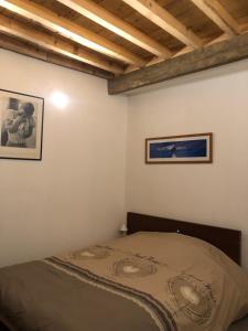 a bedroom with a bed and two pictures on the wall at Lulu Philipp coté cour in Saint-Étienne