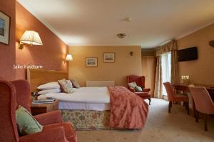 um quarto de hotel com uma cama, uma mesa e cadeiras em Sid Valley Country House Hotel em Sidmouth